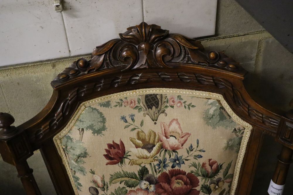 A late Victorian carved walnut upholstered open armchair